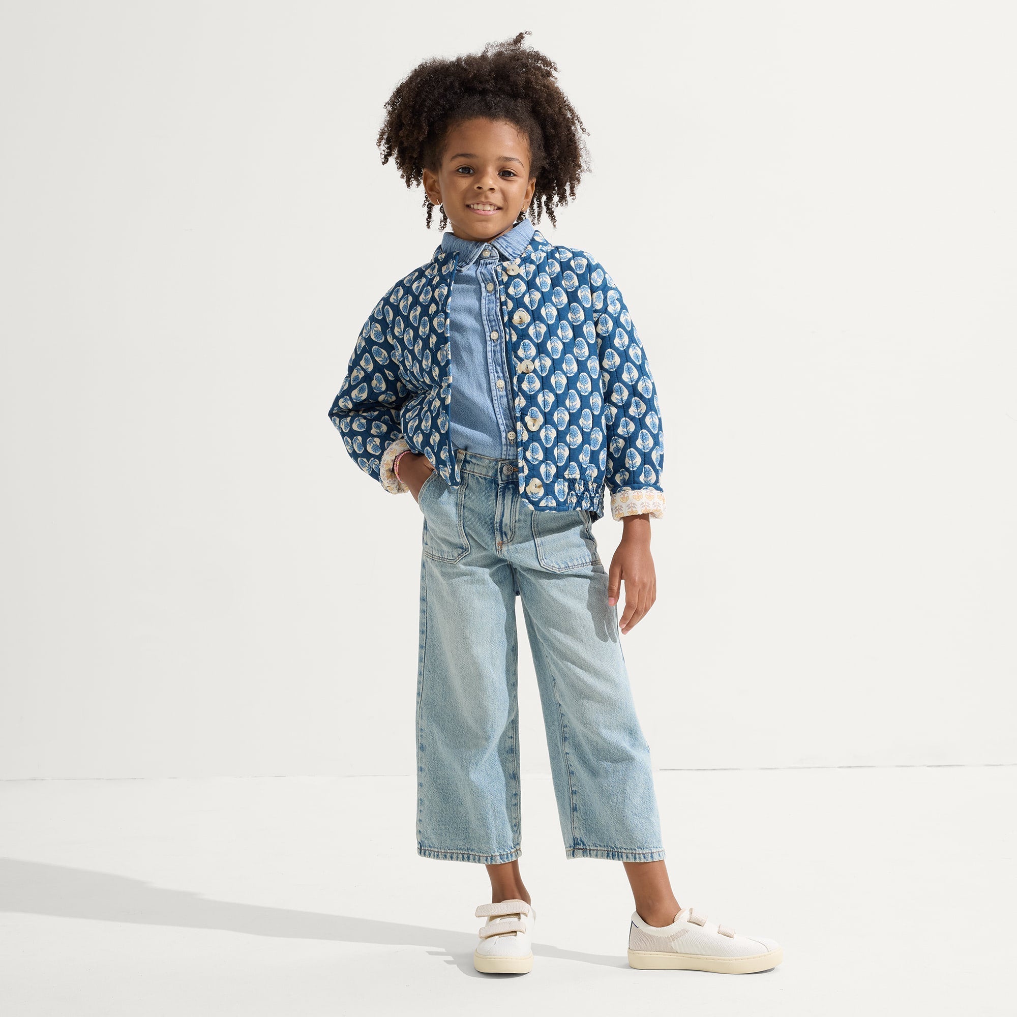 A child modeling The Kids Strap Sneaker in Vanilla Ice.
